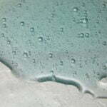 Blue cream liquid gel serum on silver texture, makeup and cosmetics background